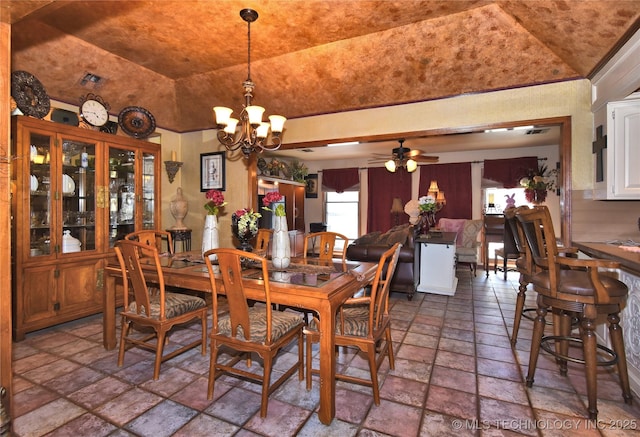 3001 Bacon Rd, Muskogee, OK 74403 - dining area with stone tile floors, vaulted ceiling, and ceiling fan with notable chandelier