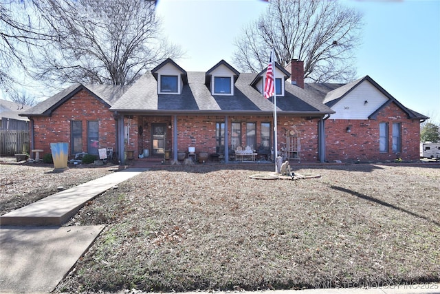 3001 Bacon Rd, Muskogee, OK 74403 - cape cod house featuring roof with shingles, covered porch, a chimney, and brick siding
