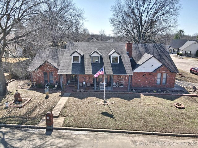 3001 Bacon Rd, Muskogee, OK 74403 - cape cod house with a porch, a chimney, a shingled roof, and brick siding