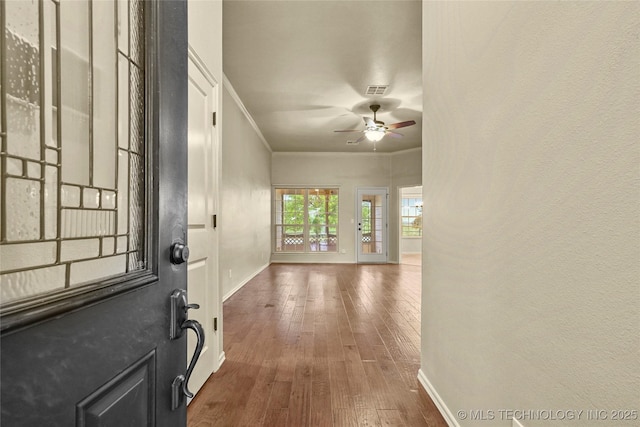entrance foyer with crown molding, visible vents, baseboards, hardwood / wood-style flooring, and a ceiling fan