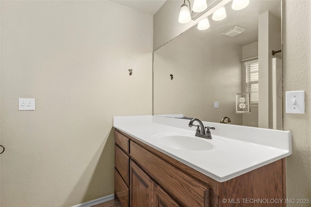 bathroom featuring vanity, baseboards, and visible vents
