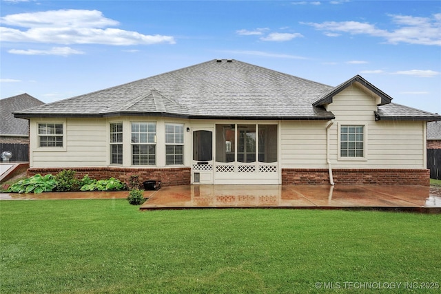 rear view of house featuring a patio area, a sunroom, brick siding, a yard, and a shingled roof