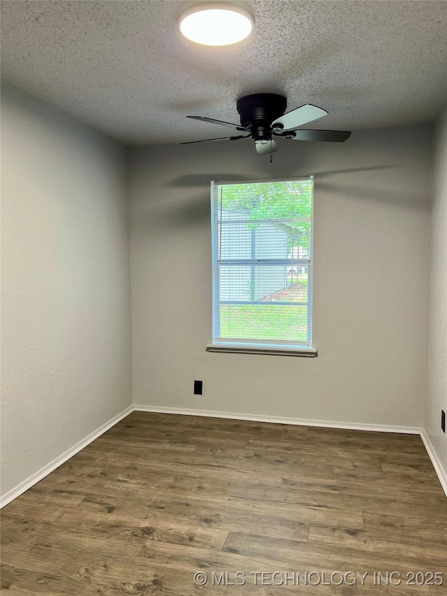spare room with a textured ceiling, a ceiling fan, wood finished floors, and baseboards