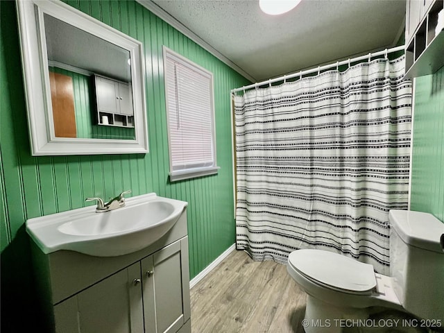 bathroom featuring a textured ceiling, crown molding, toilet, wood finished floors, and vanity