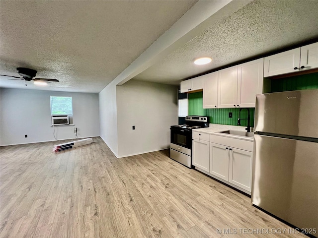 kitchen with white cabinetry, a textured ceiling, appliances with stainless steel finishes, and a sink