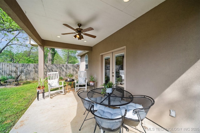 539 N Gunter St, Vinita, OK 74301 - view of patio / terrace featuring fence, outdoor dining space, a ceiling fan, and french doors