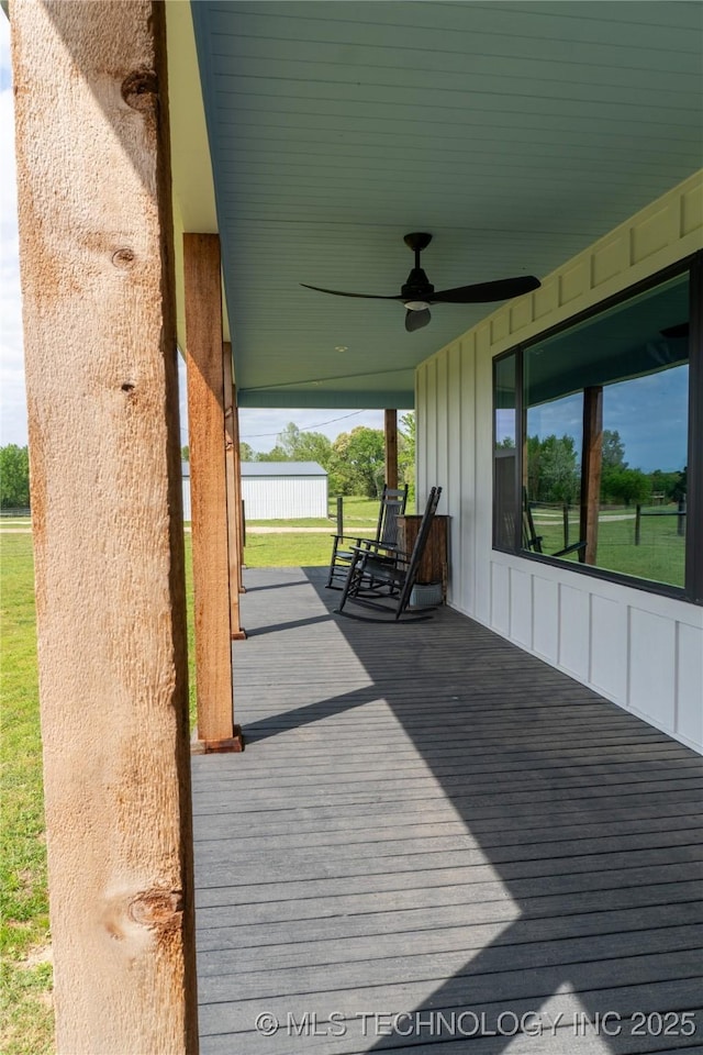 wooden deck featuring a yard and ceiling fan