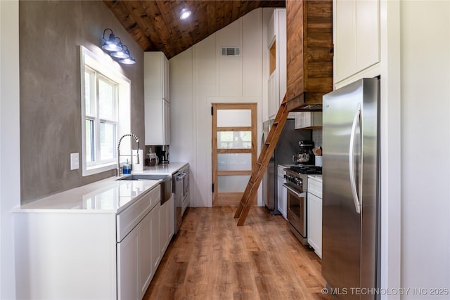 kitchen with light wood finished floors, wooden ceiling, visible vents, white cabinets, and appliances with stainless steel finishes