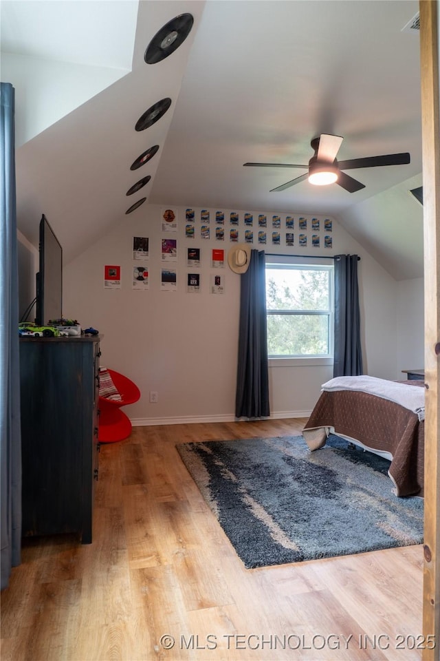 bedroom featuring baseboards, wood finished floors, a ceiling fan, and vaulted ceiling