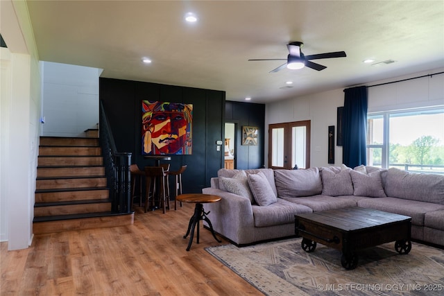 living area with recessed lighting, a ceiling fan, stairs, and wood finished floors