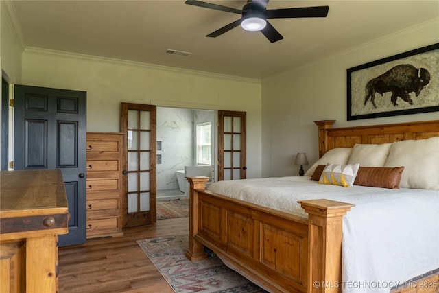 bedroom with wood finished floors, visible vents, french doors, and crown molding