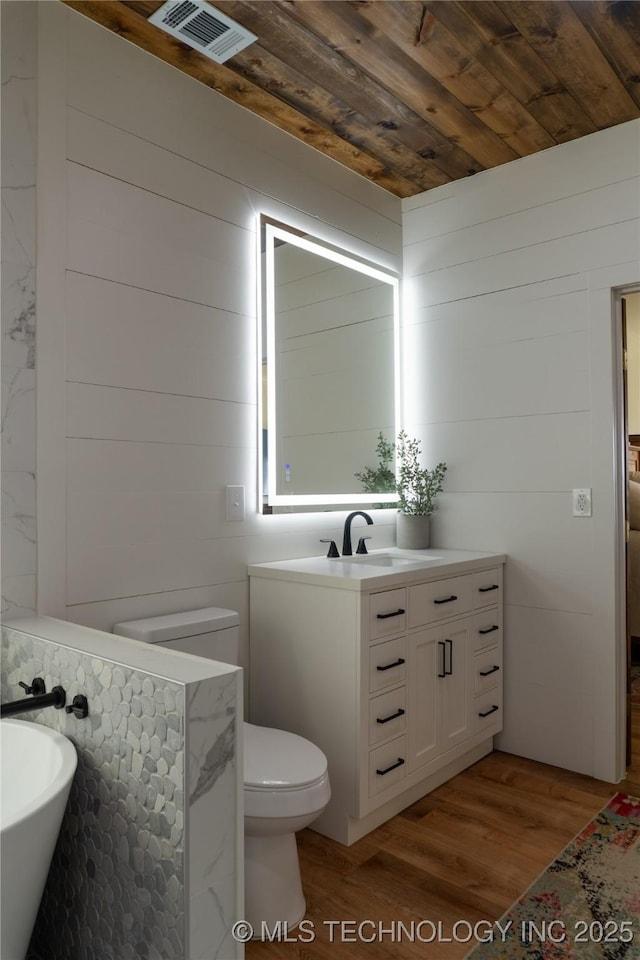 bathroom with visible vents, wooden ceiling, toilet, wood finished floors, and vanity