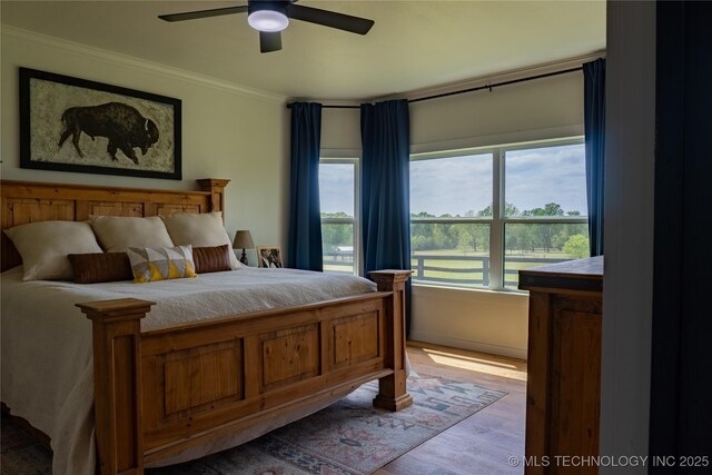 bedroom featuring crown molding, ceiling fan, and light wood-type flooring