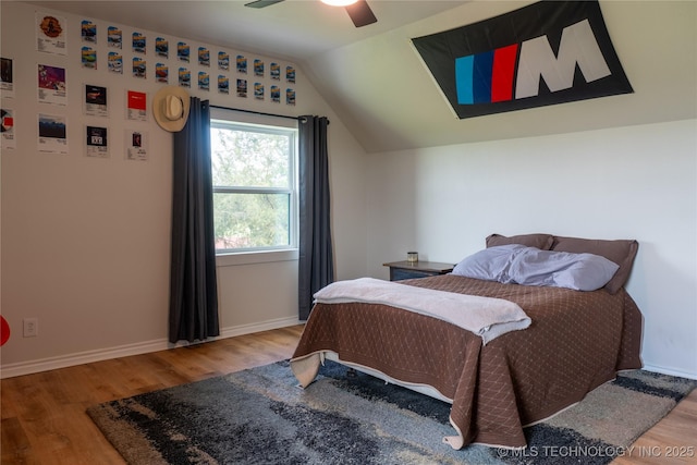 bedroom featuring lofted ceiling, wood finished floors, a ceiling fan, and baseboards