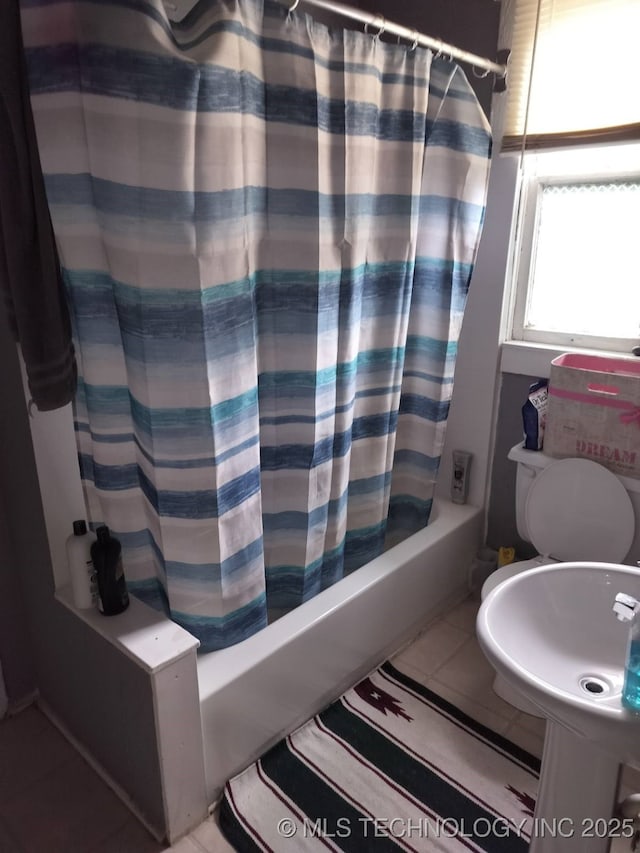 full bath featuring shower / bath combination with curtain, tile patterned flooring, and a sink