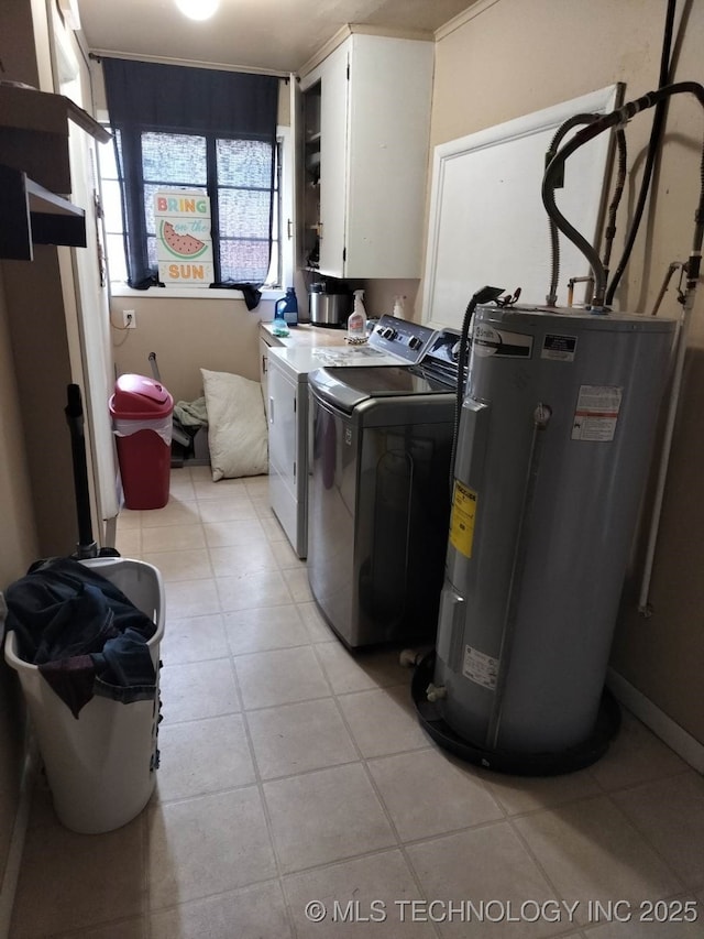 laundry area featuring light tile patterned floors, washer and dryer, cabinet space, and electric water heater