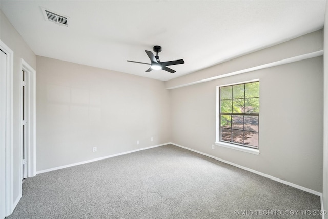 spare room with visible vents, a ceiling fan, baseboards, and carpet floors