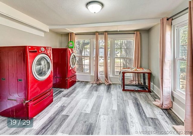 laundry area with washing machine and dryer, a textured ceiling, wood finished floors, and laundry area