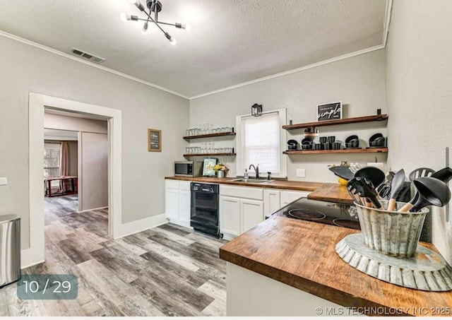 kitchen featuring open shelves, crown molding, a sink, visible vents, and butcher block countertops