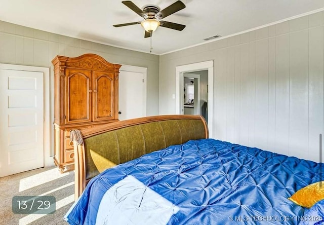 bedroom featuring visible vents, ornamental molding, a ceiling fan, and carpet floors