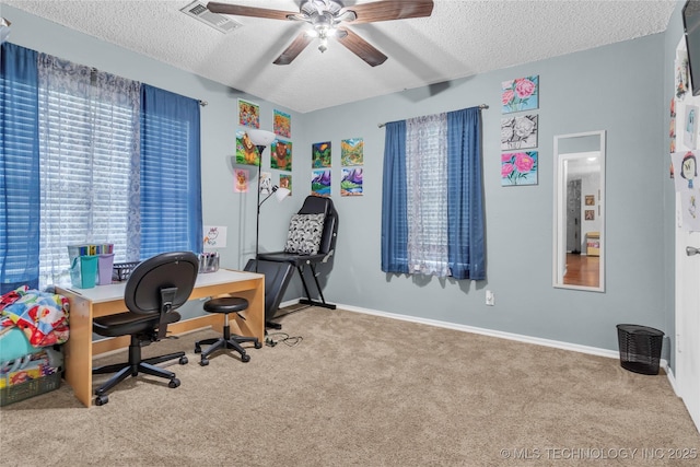 carpeted home office with baseboards, visible vents, ceiling fan, and a textured ceiling