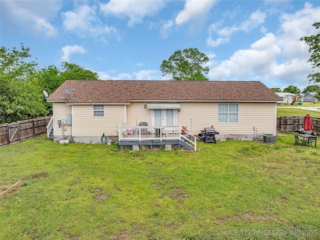 rear view of house with a deck, a fenced backyard, cooling unit, and a yard