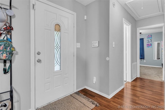 foyer entrance with dark wood finished floors, visible vents, and baseboards