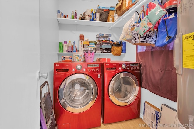 laundry area featuring wood finished floors, laundry area, and washer and clothes dryer