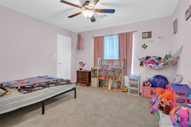 carpeted bedroom with a ceiling fan and visible vents