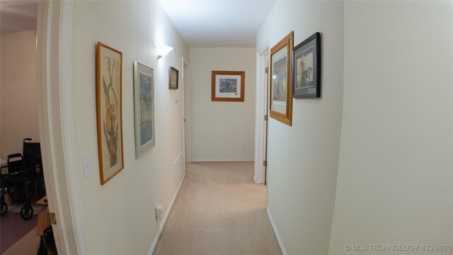 hallway with light carpet and baseboards