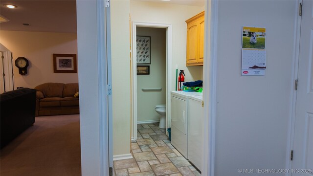 clothes washing area featuring recessed lighting, washer and dryer, cabinet space, stone finish flooring, and baseboards