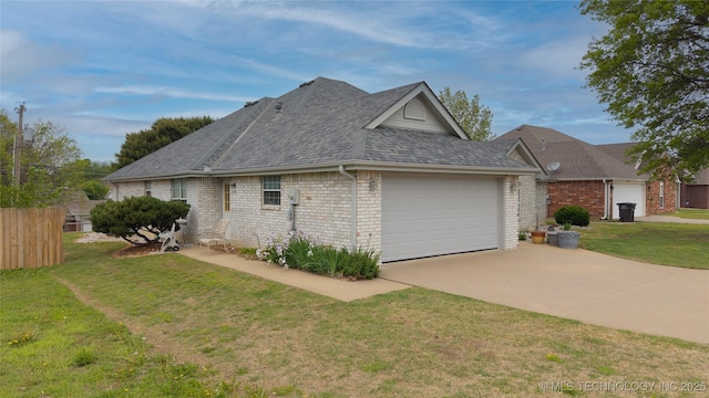 view of side of home featuring a lawn, a shingled roof, concrete driveway, and an attached garage