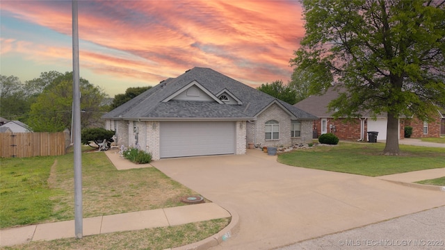 ranch-style home with driveway, roof with shingles, an attached garage, fence, and brick siding