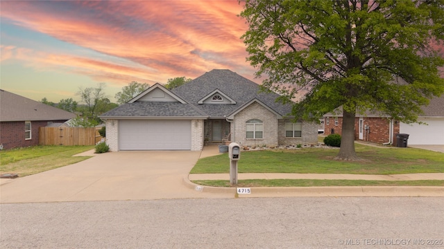 ranch-style house with a front lawn, concrete driveway, brick siding, and a garage