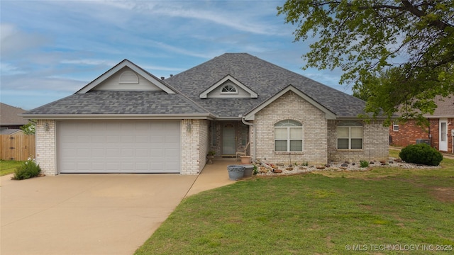 ranch-style house featuring a front yard, a shingled roof, driveway, brick siding, and an attached garage