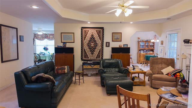 living room with a wealth of natural light, a ceiling fan, crown molding, and light colored carpet