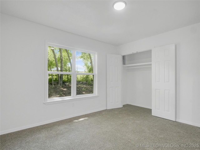 unfurnished bedroom with baseboards, carpet, and a closet