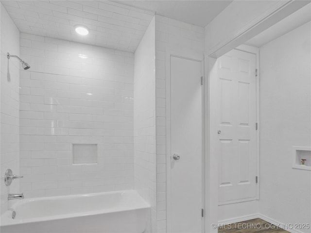 full bathroom featuring washtub / shower combination and baseboards