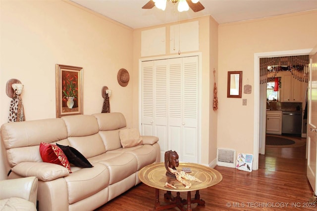 living room with visible vents, wood finished floors, a ceiling fan, and ornamental molding