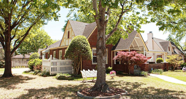view of side of home featuring fence, roof with shingles, a chimney, and a yard