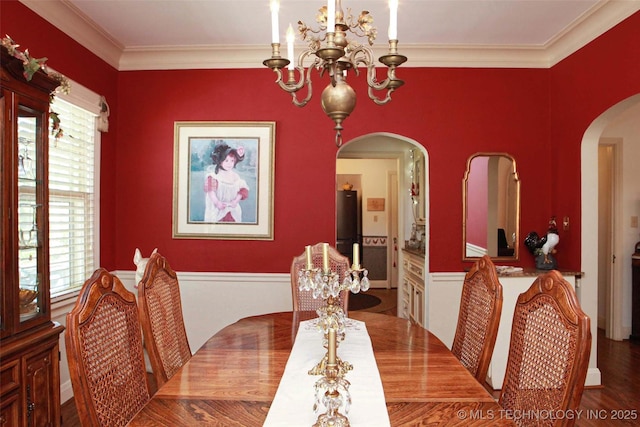 dining space featuring ornamental molding, arched walkways, a notable chandelier, and plenty of natural light
