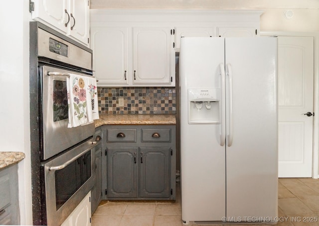 kitchen with white refrigerator with ice dispenser, white cabinets, gray cabinets, and light tile patterned flooring