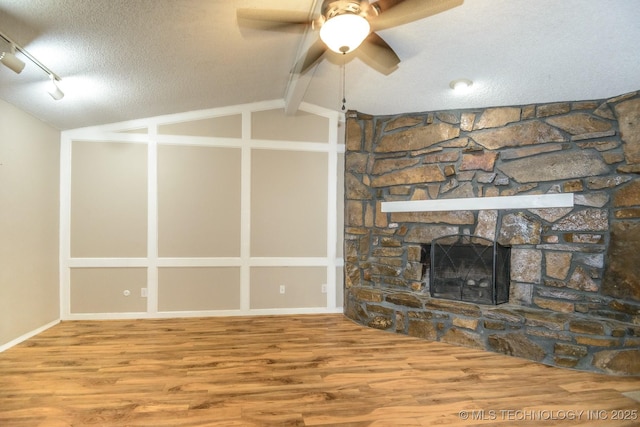 unfurnished living room featuring wood finished floors, a ceiling fan, a textured ceiling, and vaulted ceiling