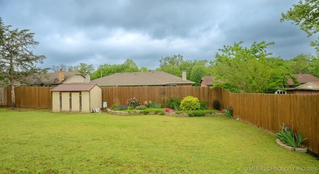 view of yard with an outdoor structure, a fenced backyard, and a storage shed