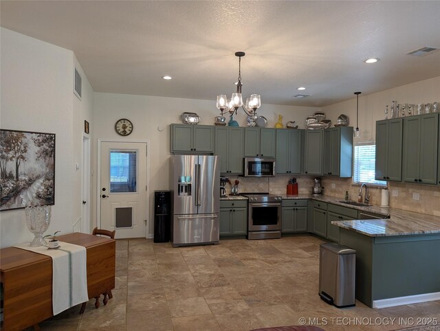 277 Oak Hollow Rd, Eufaula, OK 74432 - kitchen with appliances with stainless steel finishes, a sink, decorative backsplash, pendant lighting, and a chandelier