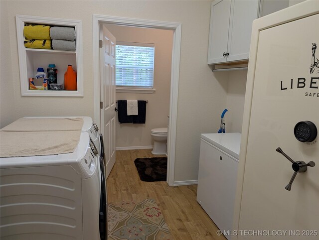 277 Oak Hollow Rd, Eufaula, OK 74432 - clothes washing area featuring cabinet space, washing machine and clothes dryer, light wood finished floors, and baseboards