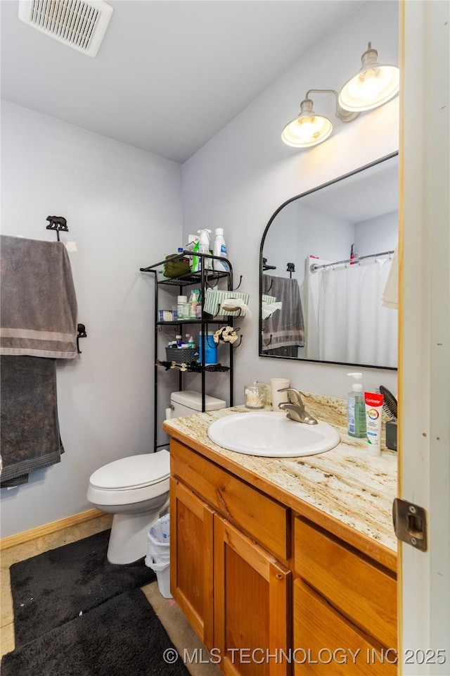 65365 E 155th Rd, Wyandotte, OK 74370 - bathroom featuring baseboards, visible vents, toilet, and vanity