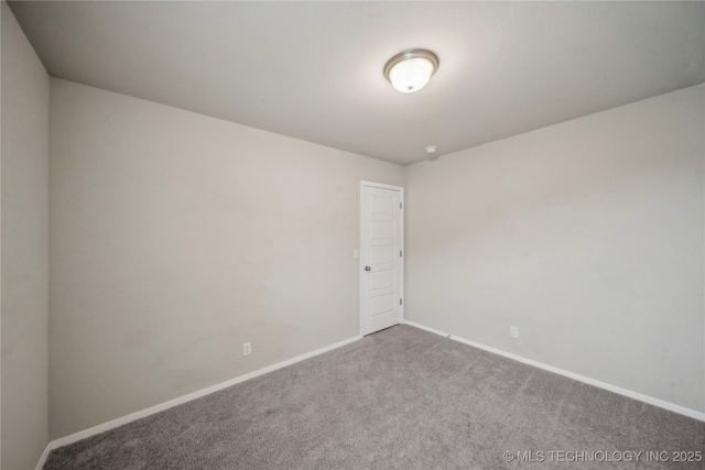 carpeted empty room featuring baseboards