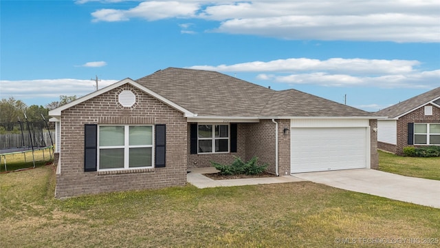 ranch-style home with a trampoline, brick siding, driveway, roof with shingles, and an attached garage
