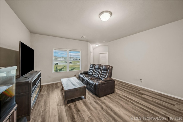 living area featuring visible vents, wood finished floors, and baseboards